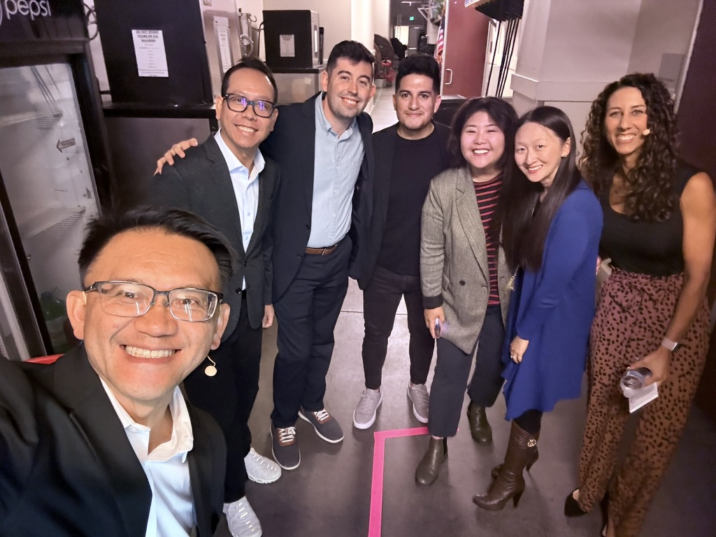 TOON smiling with an international group of speakers and collaborators backstage