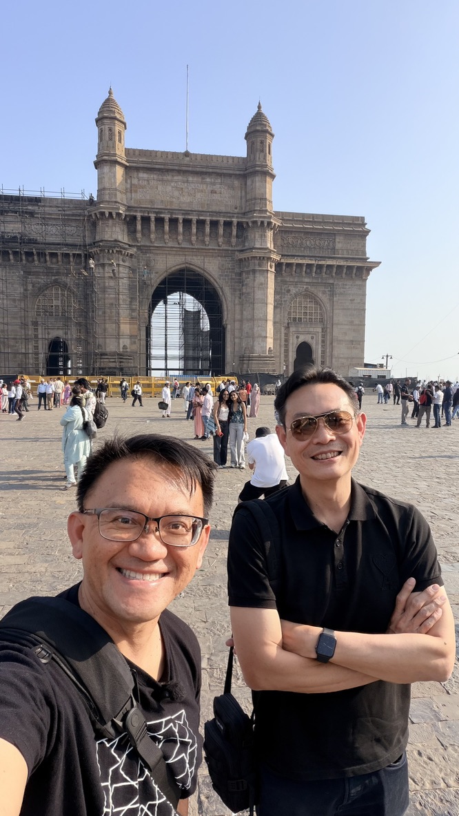 Two travellers taking a selfie before the Gateway of India, Mumbai, India.