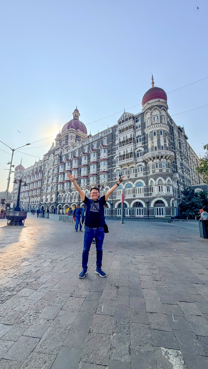 Traveller standing before the Taj Mahal Palace hotel, Mumbai, India.