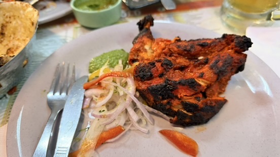 Charred chicken with onions and green chutney at Leopold Café, Mumbai, India.