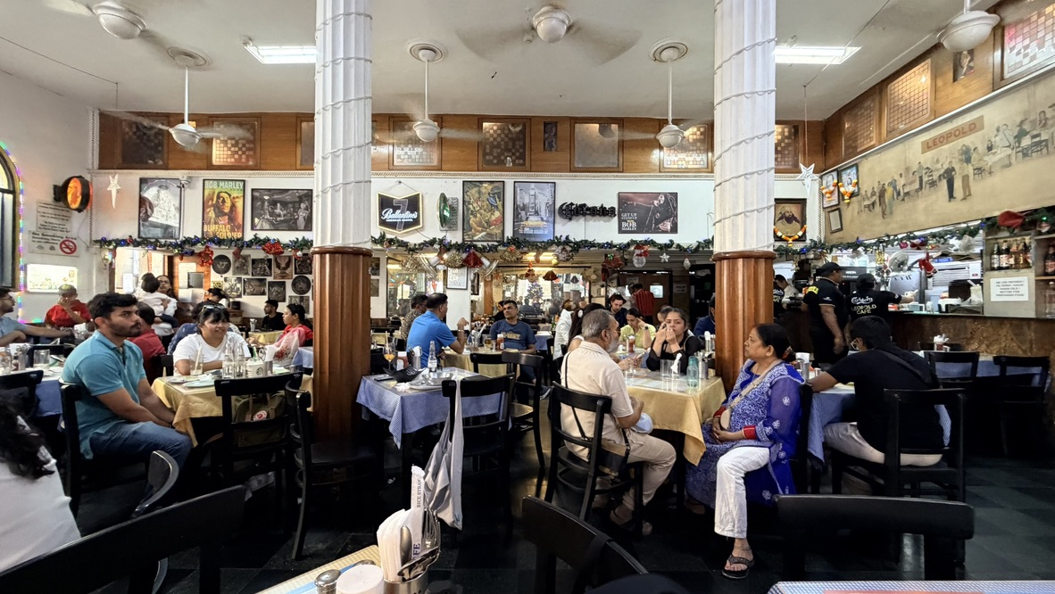 Busy dining room inside Leopold Café, Mumbai, India.