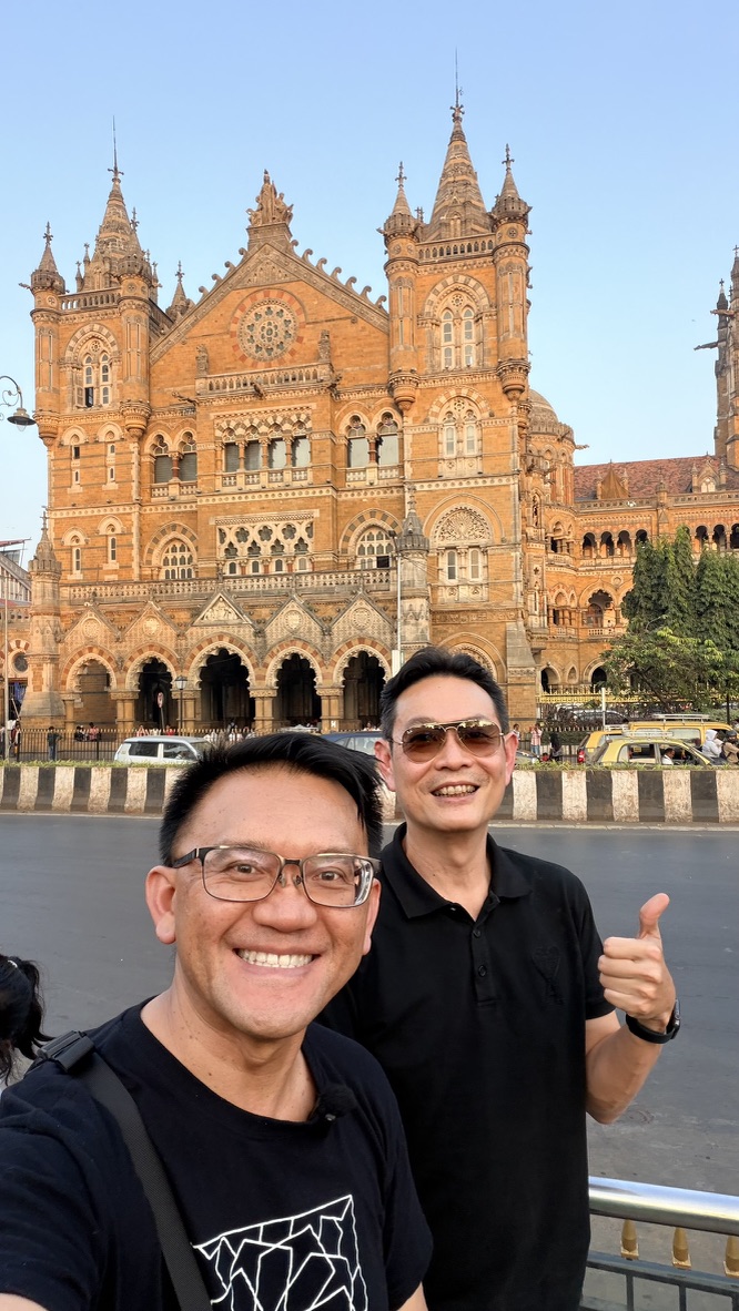 Two travellers before Chhatrapati Shivaji Maharaj Terminus, Mumbai, India.