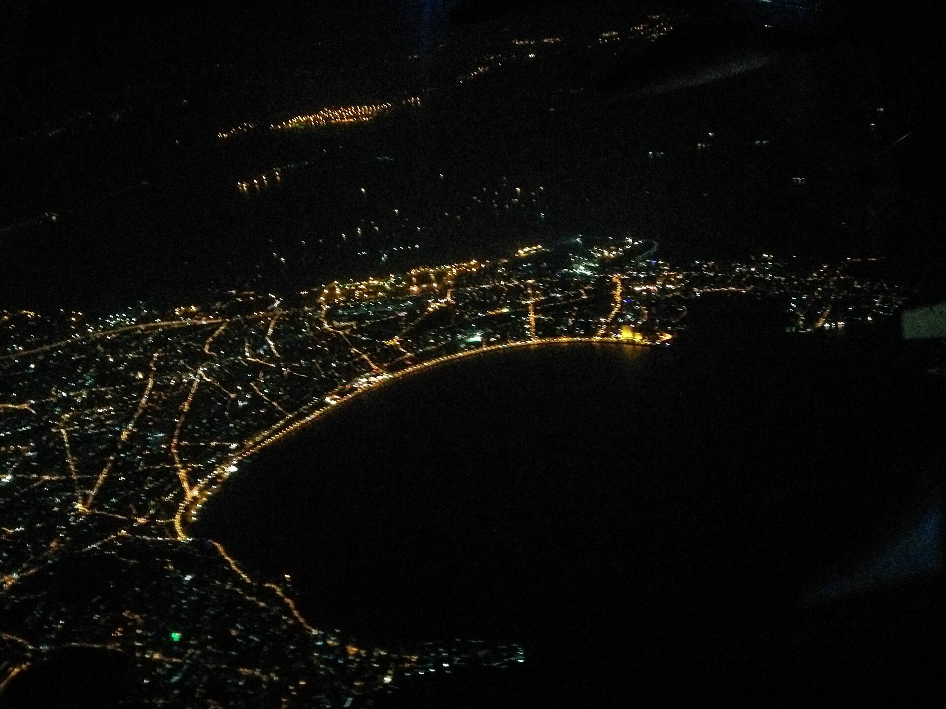 Aerial night view of illuminated Marine Drive curving around Back Bay, Mumbai, India.