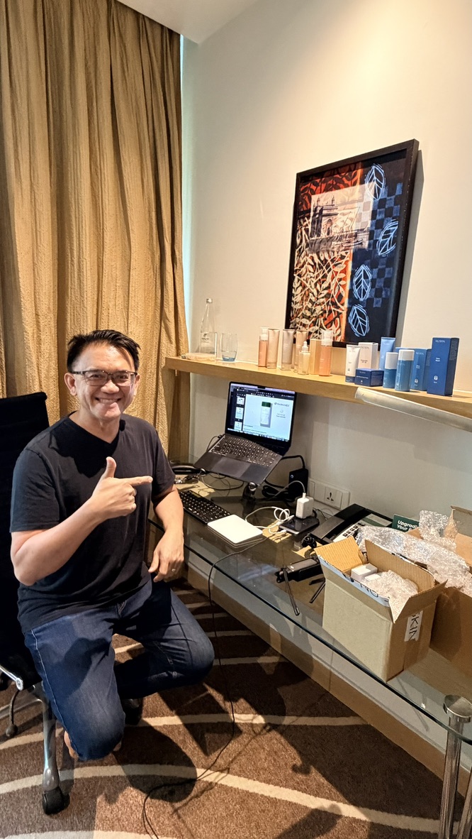 Traveller beside product samples and a laptop workstation in a Mumbai hotel room, India.