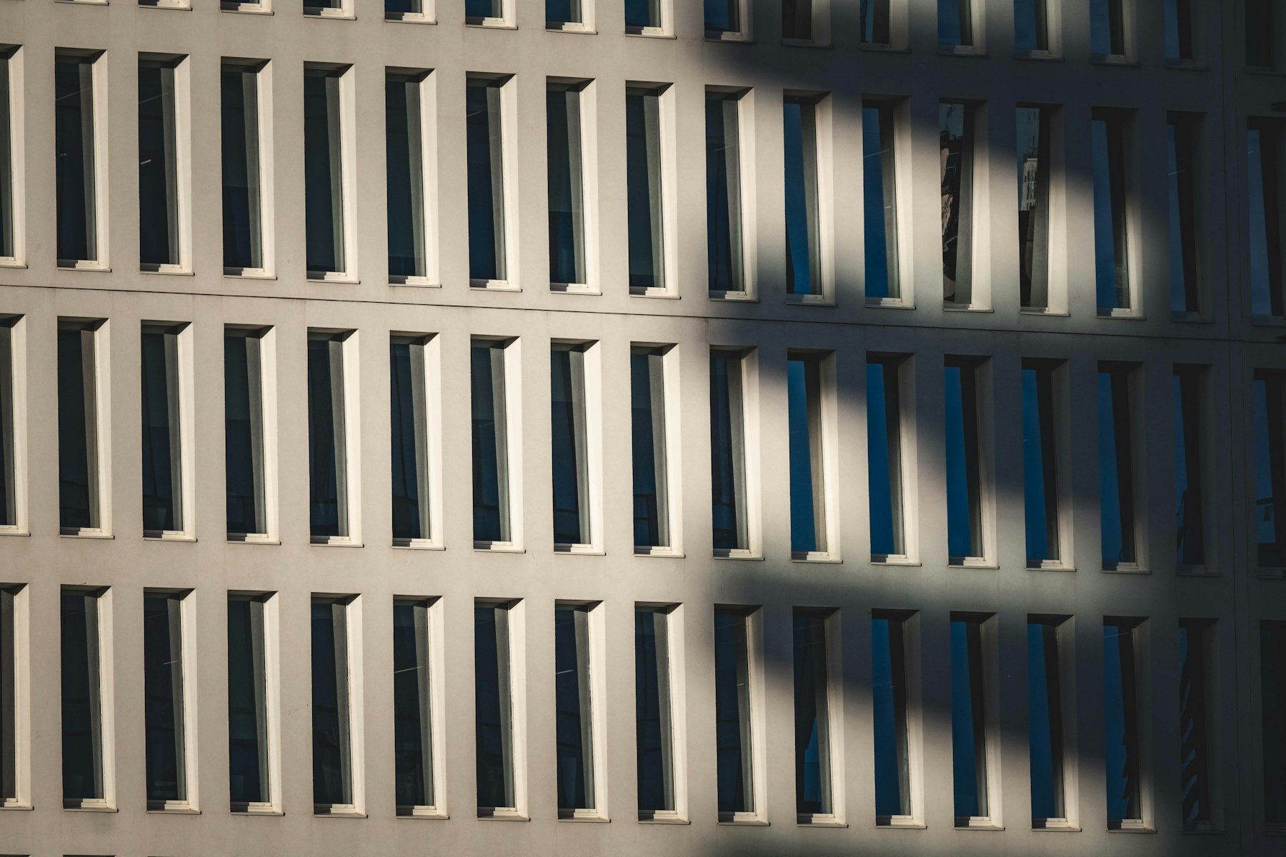 Modern architecture shaped by repeating windows, light, and shadow