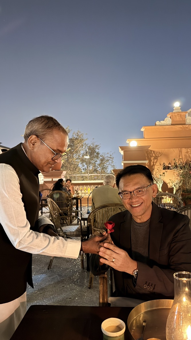 A server presenting TOON with a red rose at Agashiye rooftop restaurant