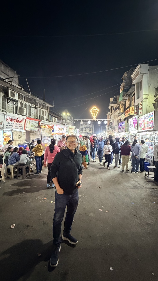 TOON standing among the food stalls and evening crowds of Manek Chowk night market