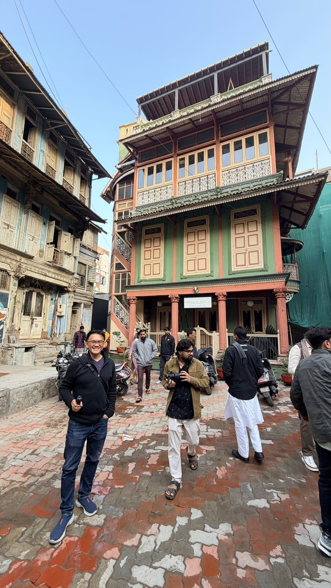 TOON standing before a colorful multi-storey heritage house in the old city of Ahmedabad