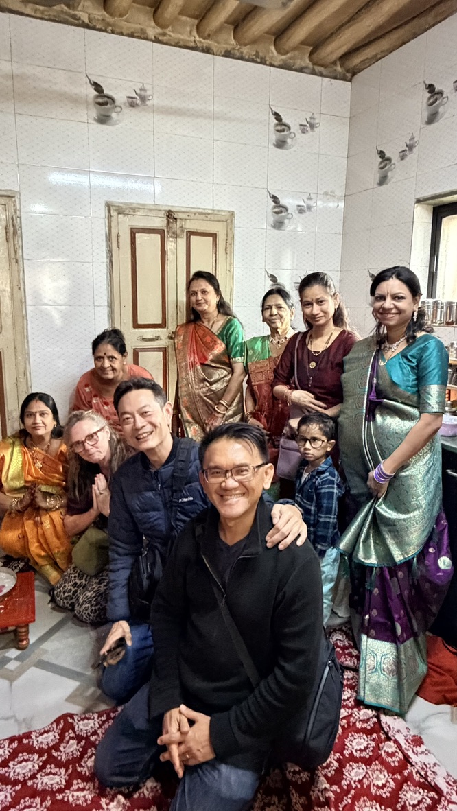TOON and his travel companion welcomed by local women and a child inside an old Ahmedabad home