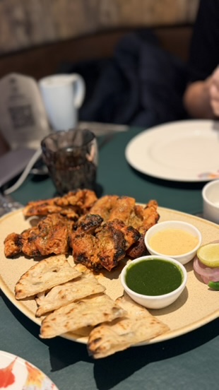 A hot platter with grilled food, flatbread, chutney, onions, and lime during evening service at ITC Narmada