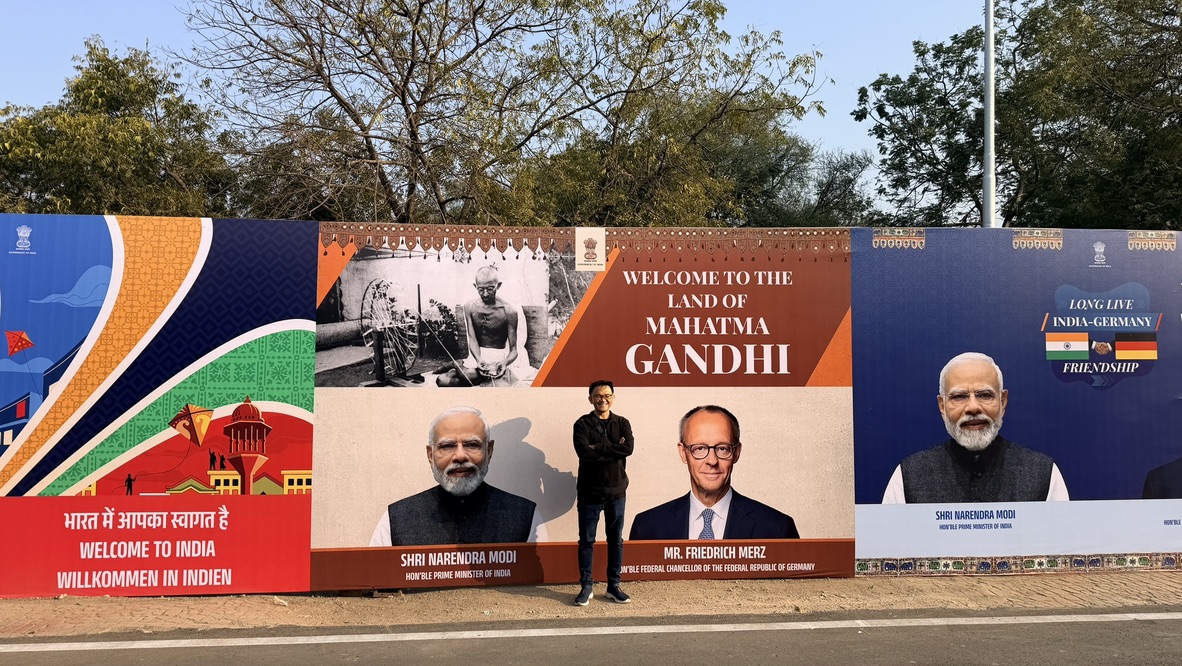 TOON in front of a welcome display describing Gujarat as the land of Mahatma Gandhi