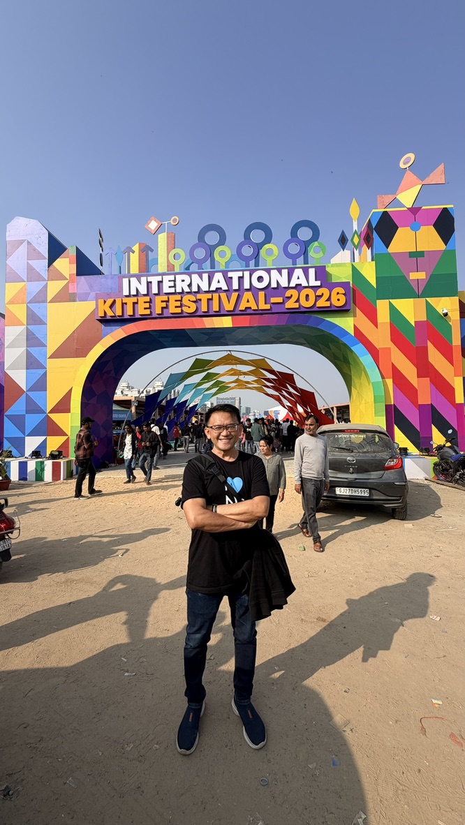 TOON standing at the colorful entrance to the International Kite Festival 2026 in Ahmedabad