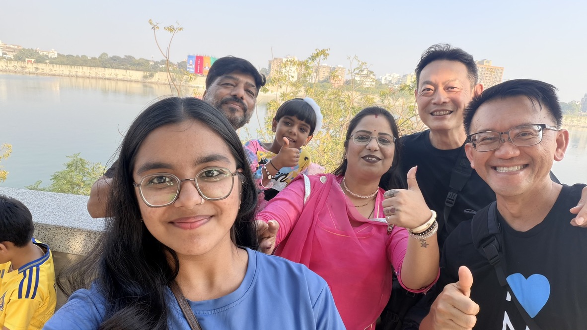 TOON and his travel companion taking a friendly group selfie with a family beside the Sabarmati River