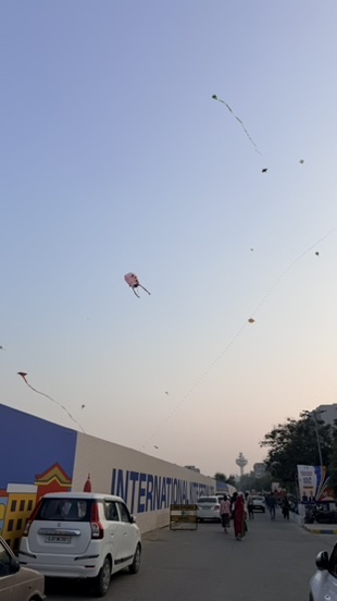 Kites floating above the approach road beside the International Kite Festival in Ahmedabad