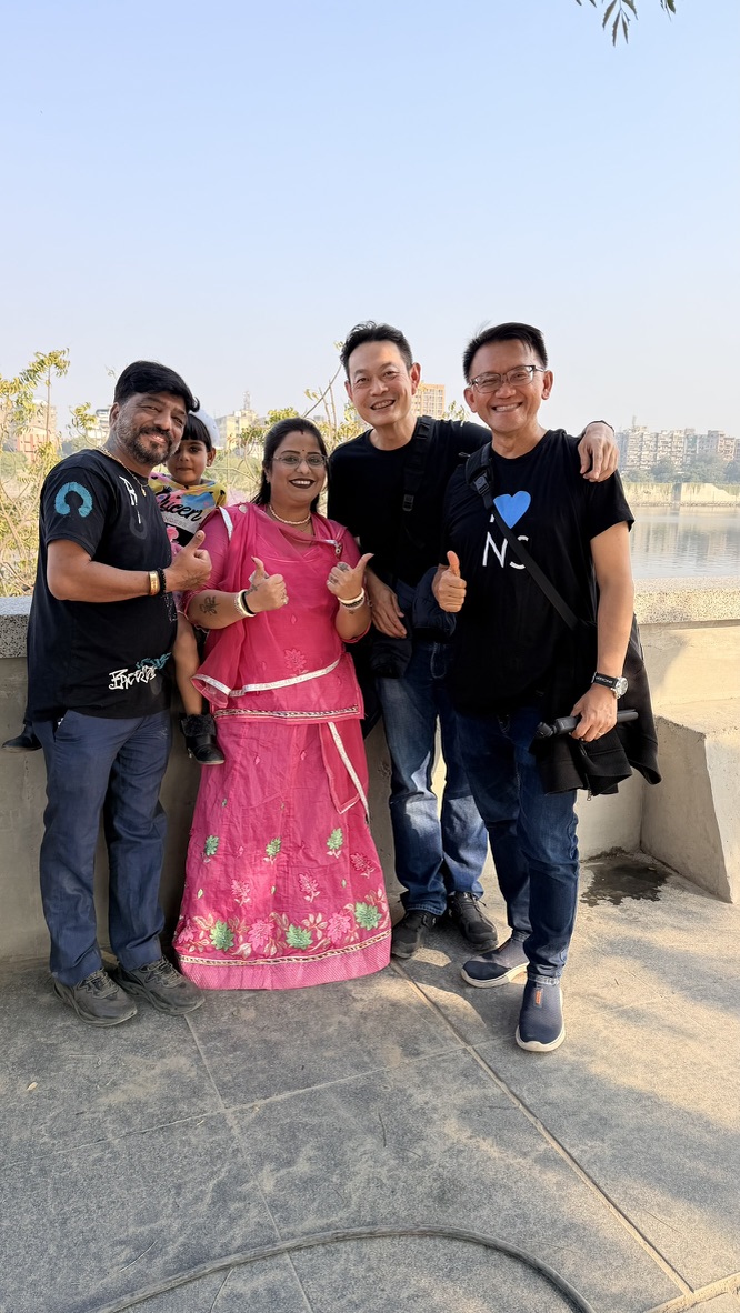 TOON and his travel companion posing with a family beside the Sabarmati Riverfront