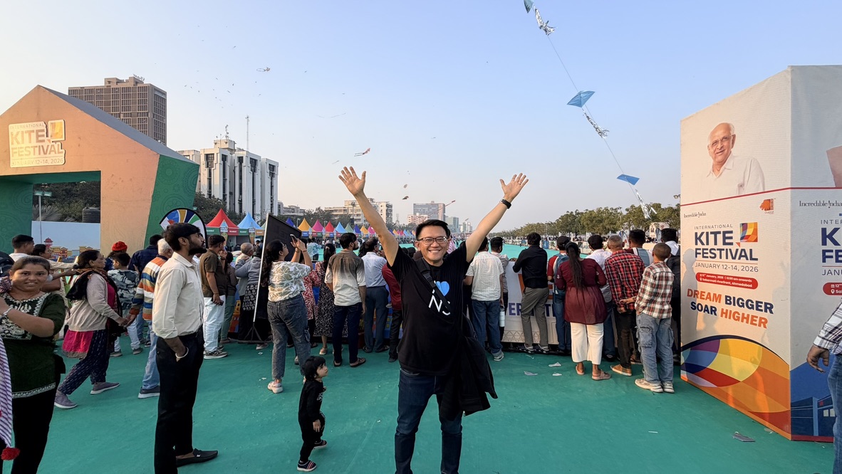 TOON raising both arms among the crowd at the International Kite Festival in Ahmedabad
