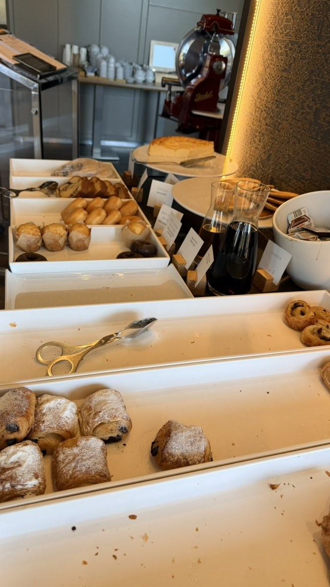 Pastries, muffins, pancakes, and condiments on the breakfast buffet