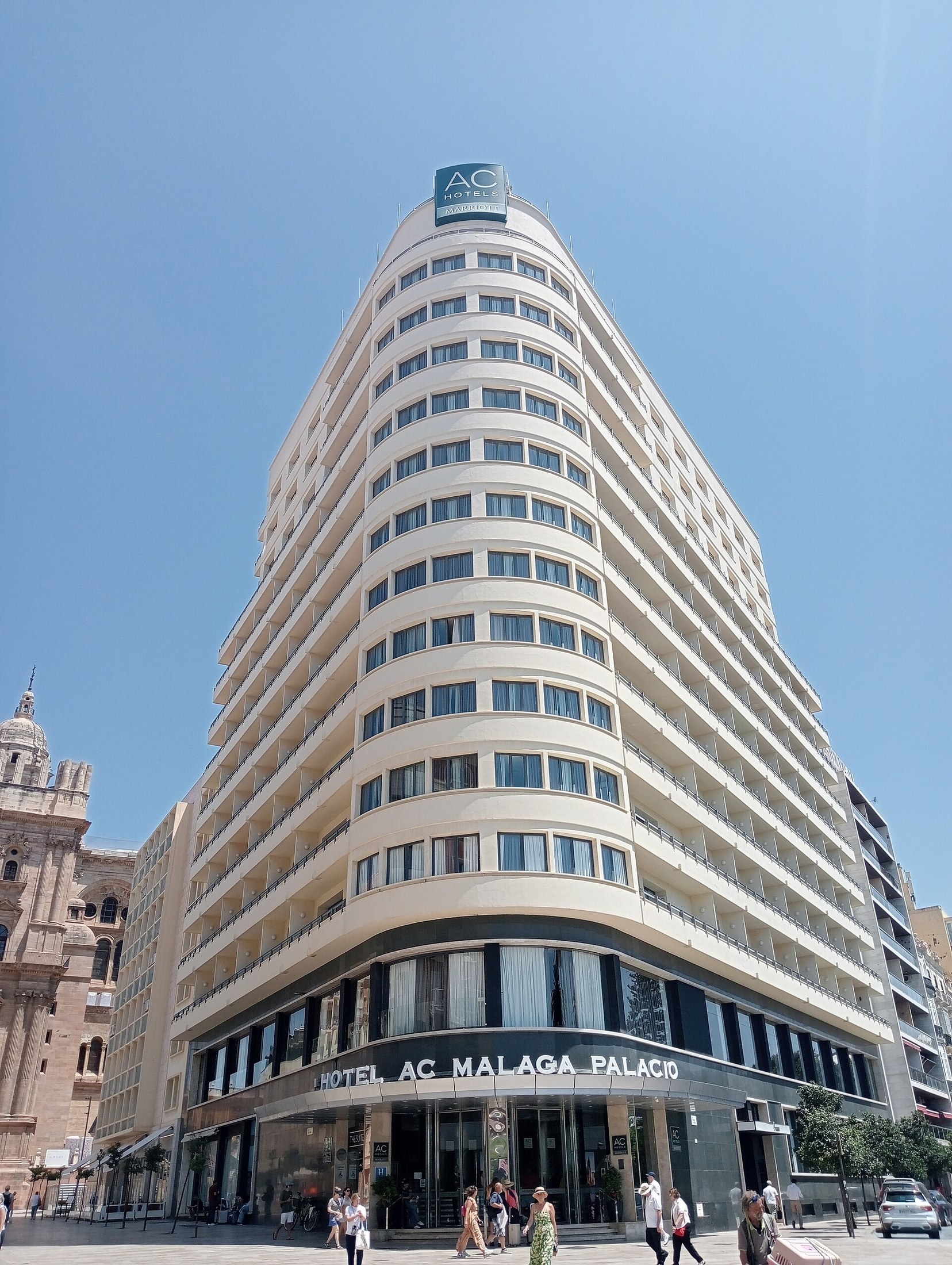 The curved exterior of AC Hotel Málaga Palacio beside the cathedral