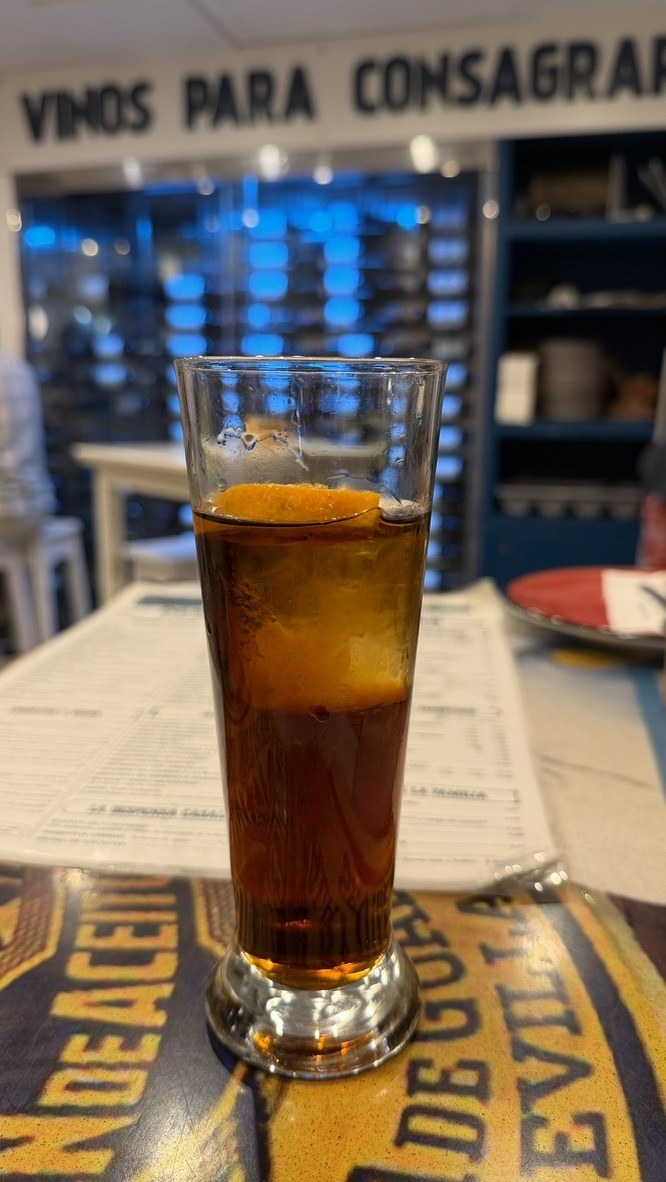 A tall glass of dark vermouth served with orange at Casa Lola