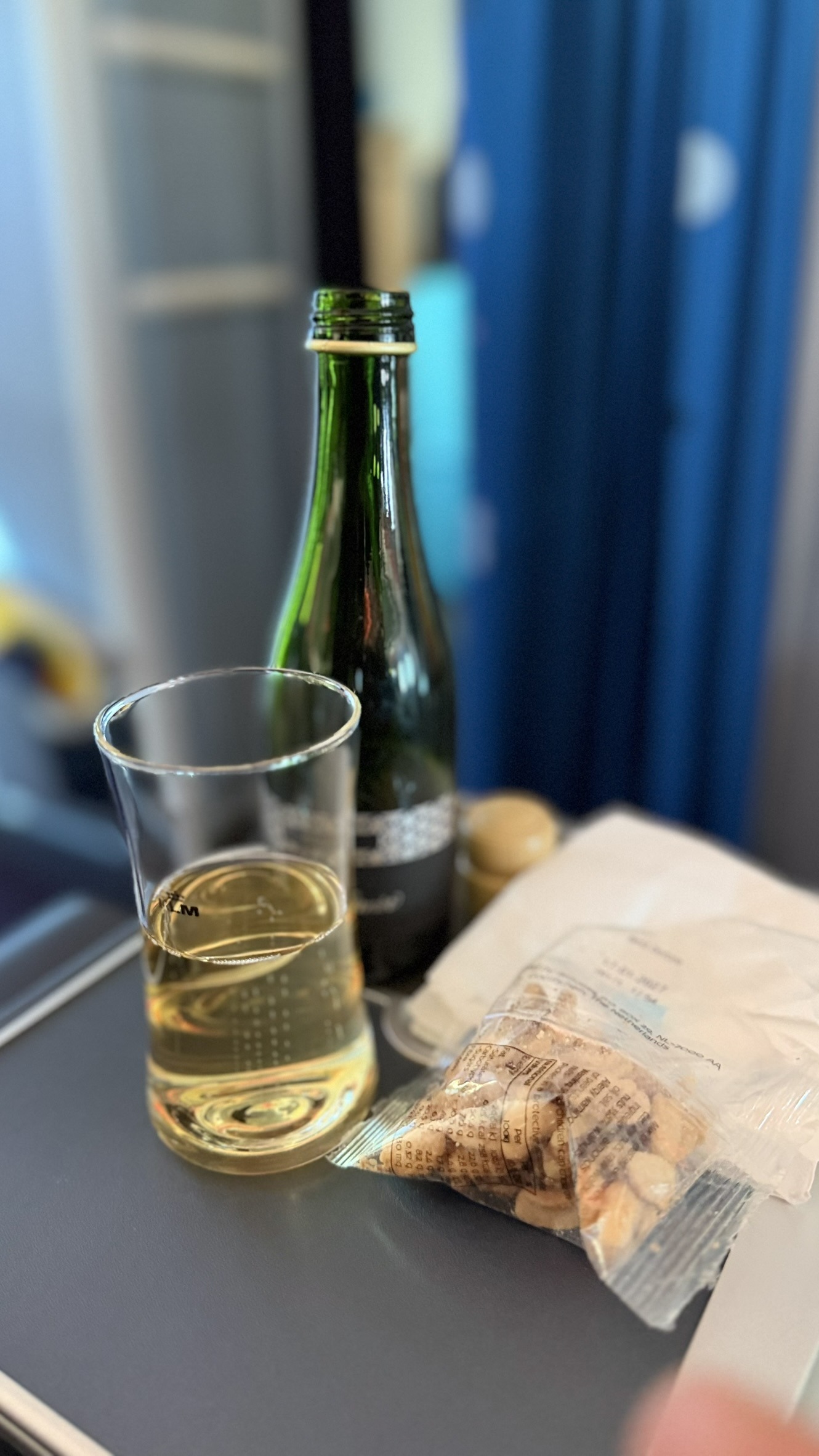 Cava served in a real glass with a small snack aboard KLM