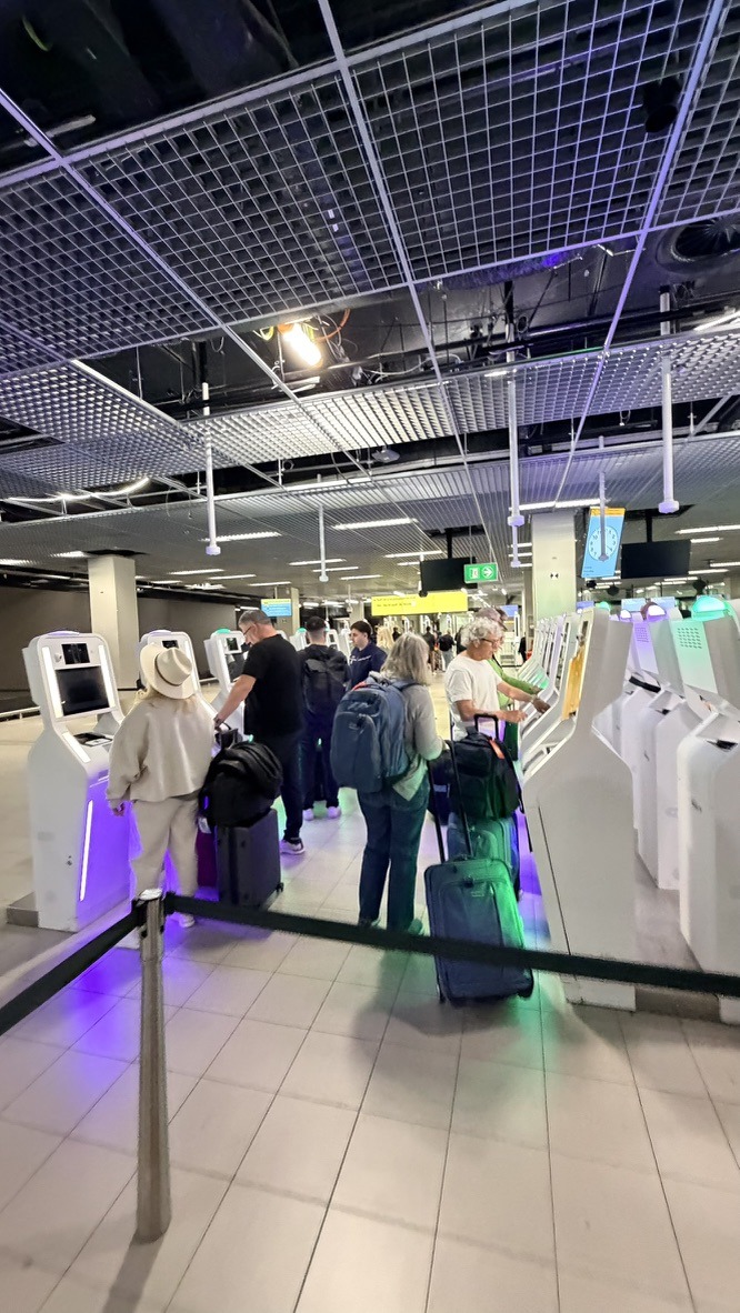 Travelers using transfer kiosks at Amsterdam Schiphol