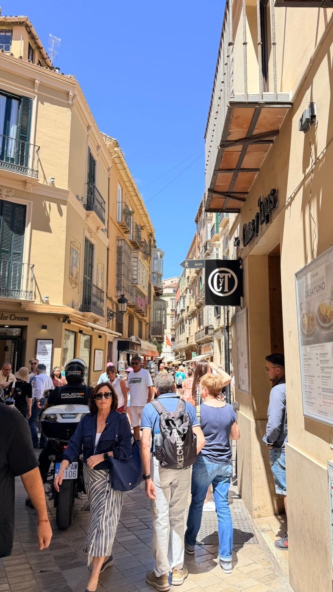 A busy narrow pedestrian street in Málaga’s historic center