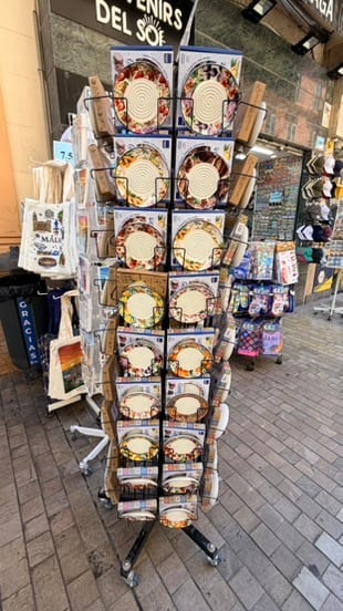 A rack of colorful ceramic souvenir plates in Málaga